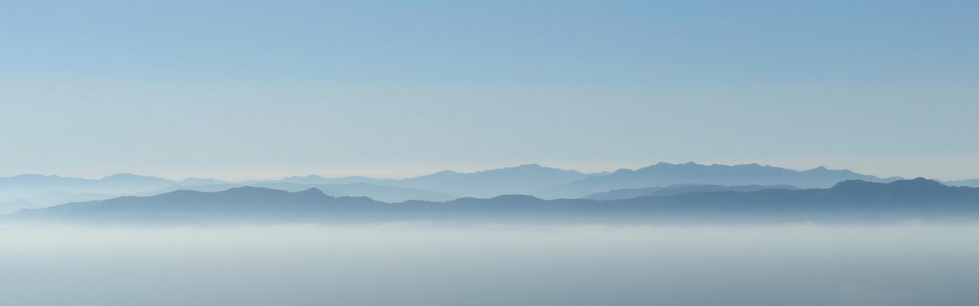Silhuetas suaves de montanhas em neblina